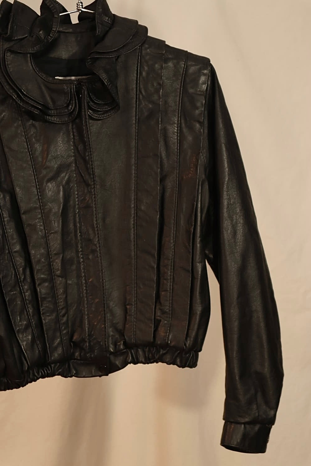 MANTEAU DE CUIR NOIR ET COLLET DE FLEUR