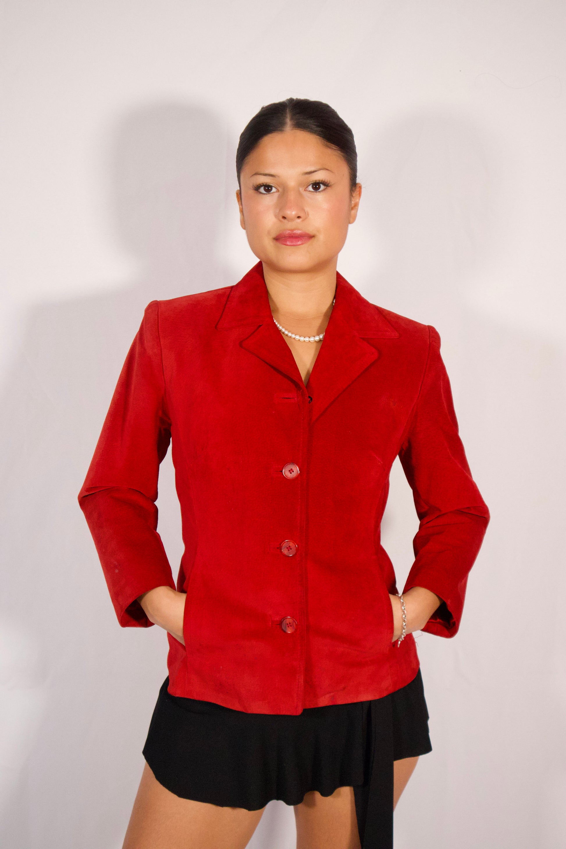 Blazer en suède rouge ajusté porté de face avec boutons