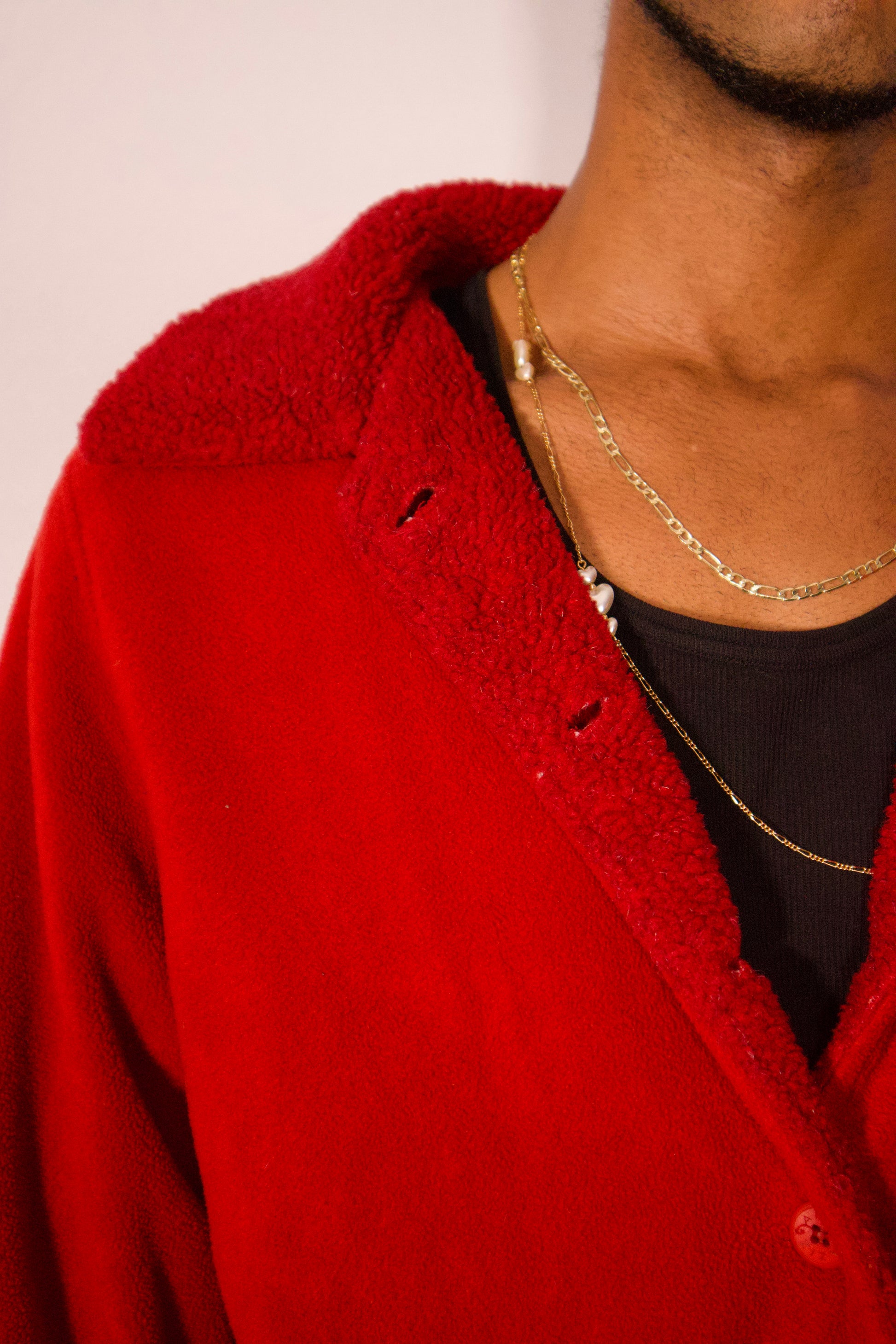 Détail col manteau sherpa rouge texture douce