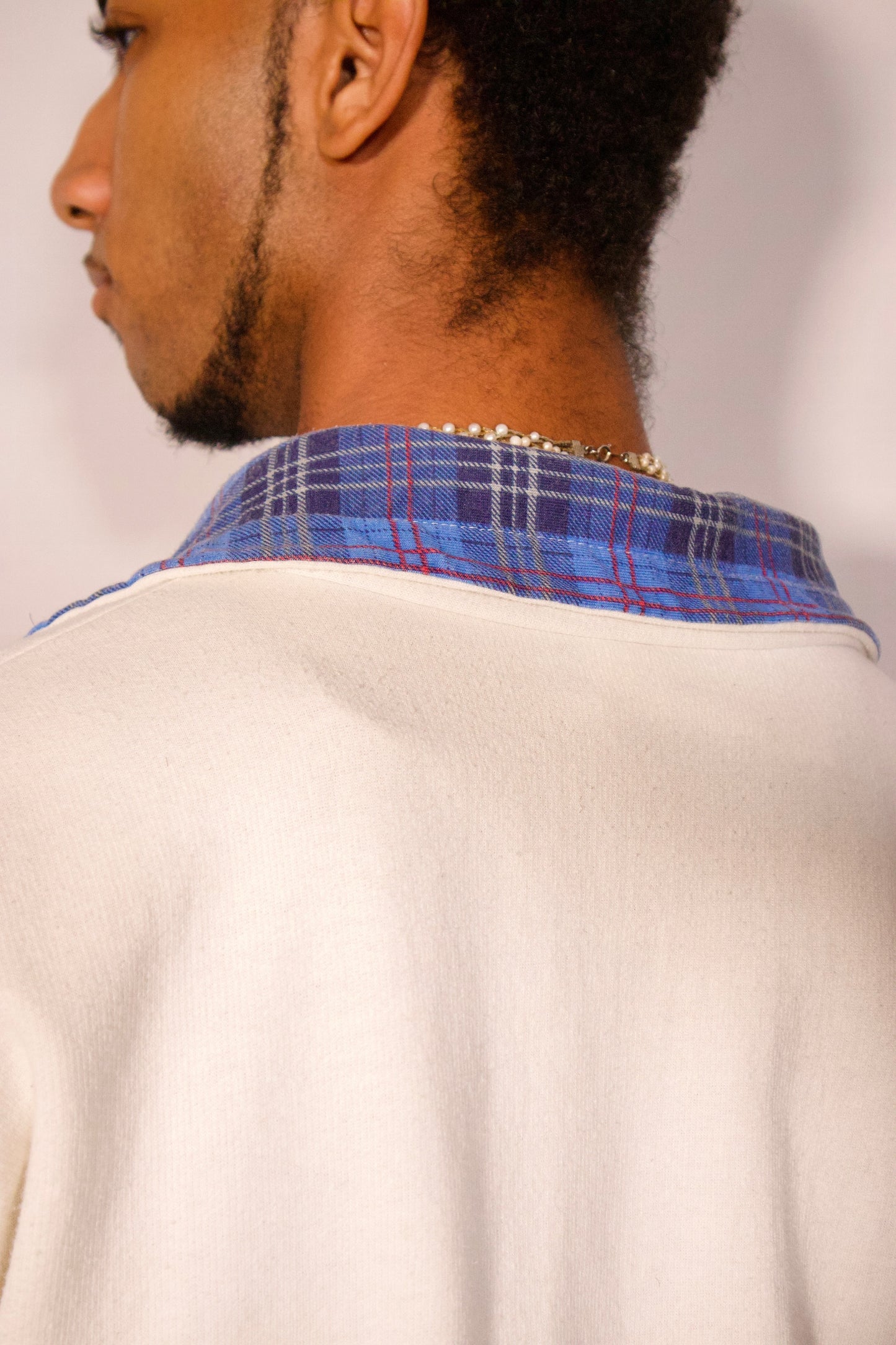 Détail col montant avec fermeture demi-zip et motif