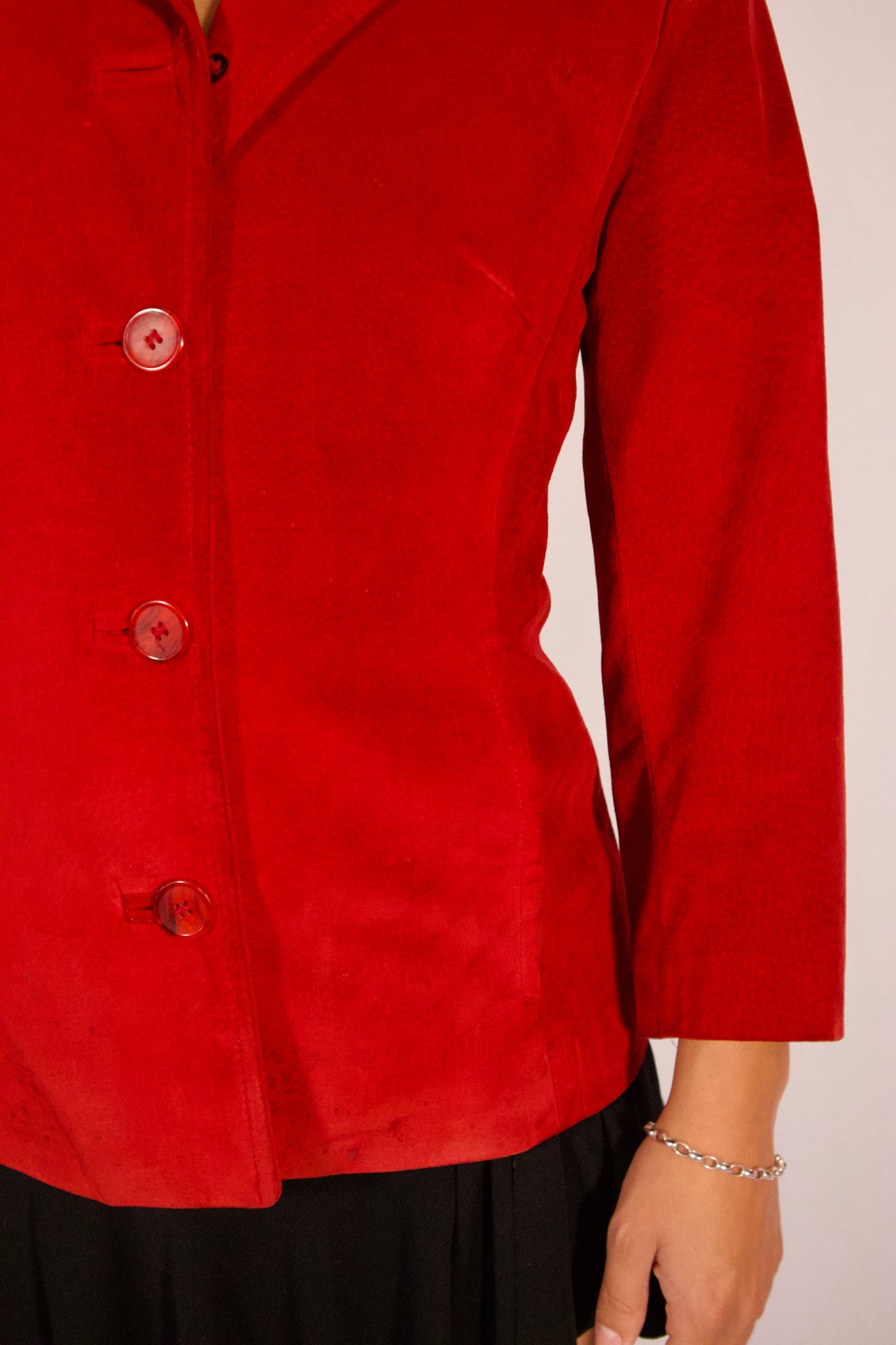 Détail manche blazer rouge en suède finition propre