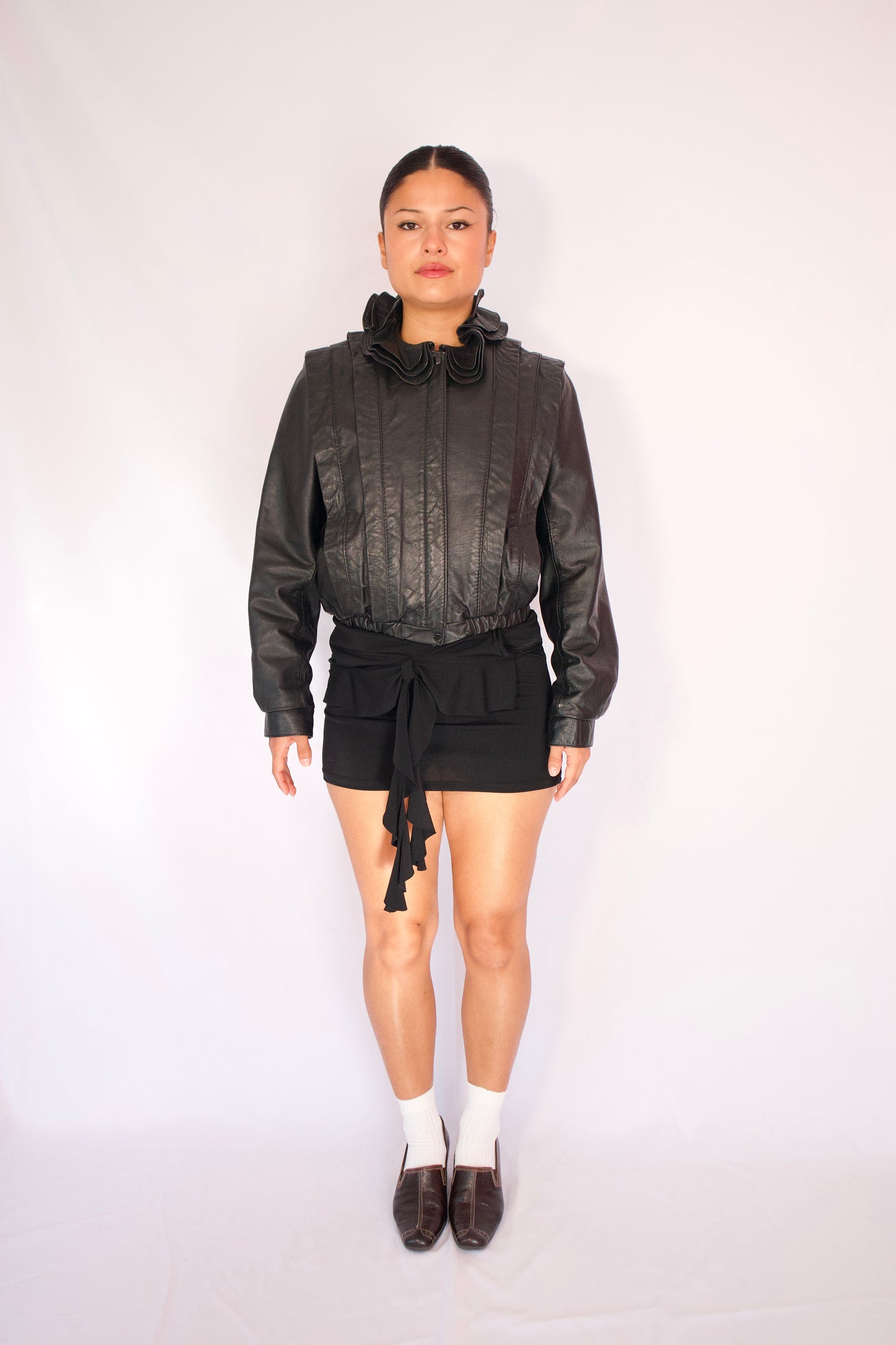 Vue de face manteau court en cuir noir coupe ajustée