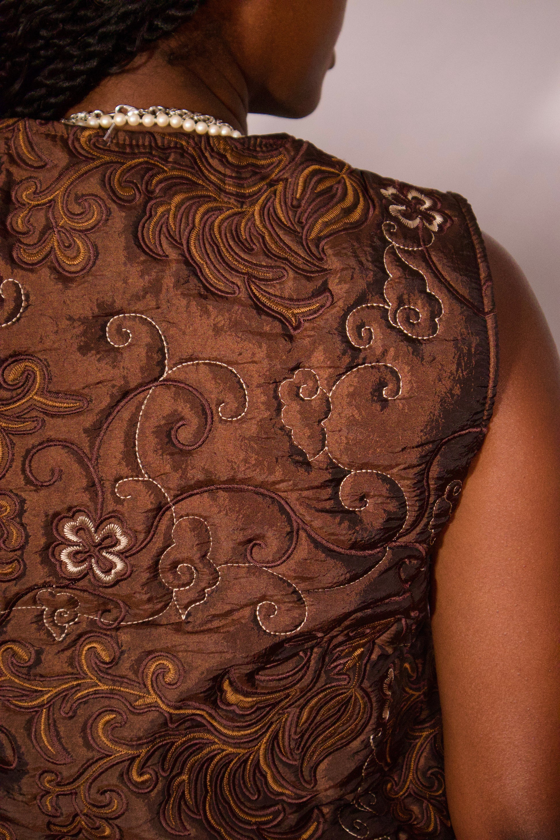 détail broderies florales veste brune