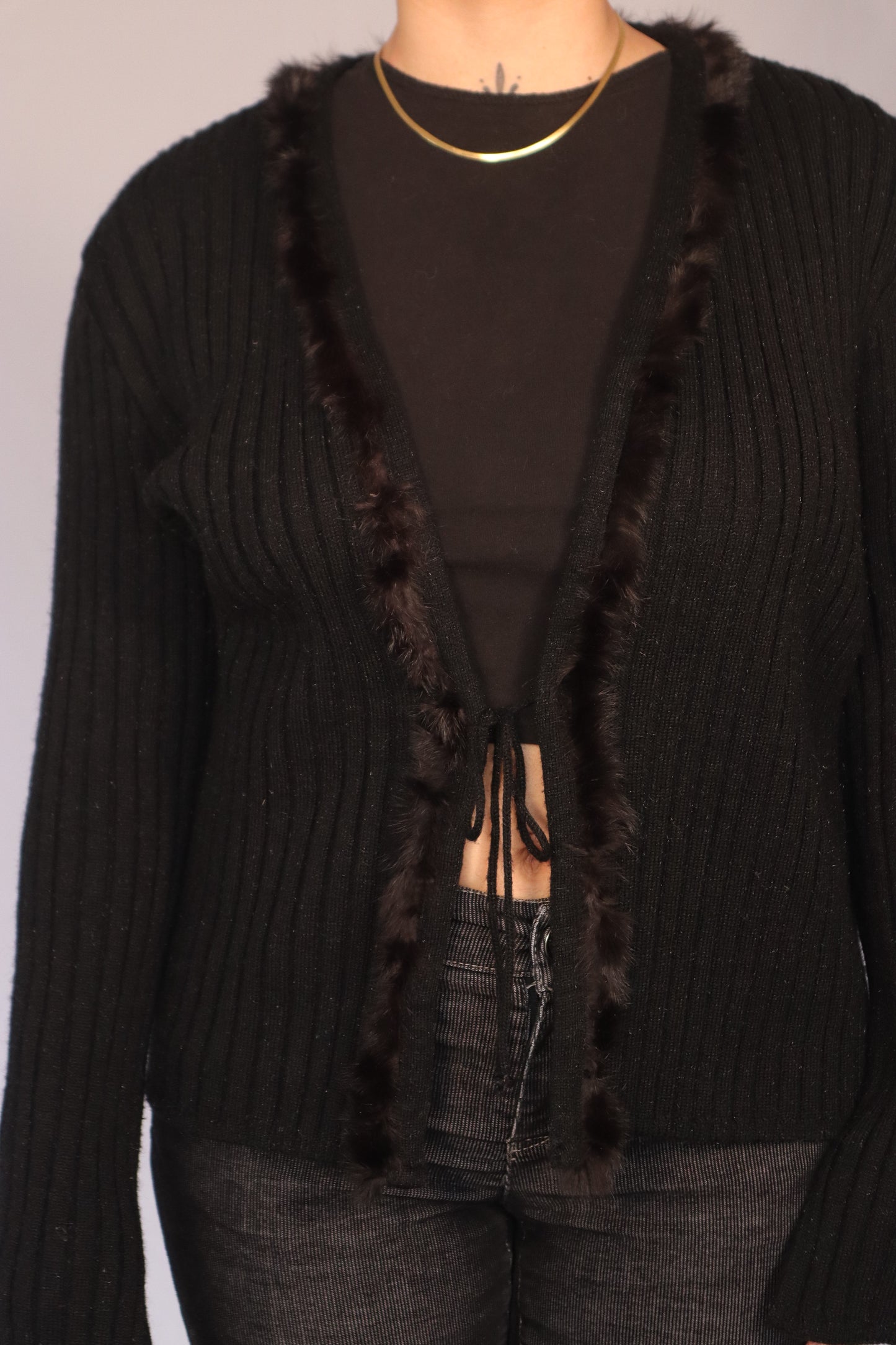 détail veste tricot noir avec faux fur
